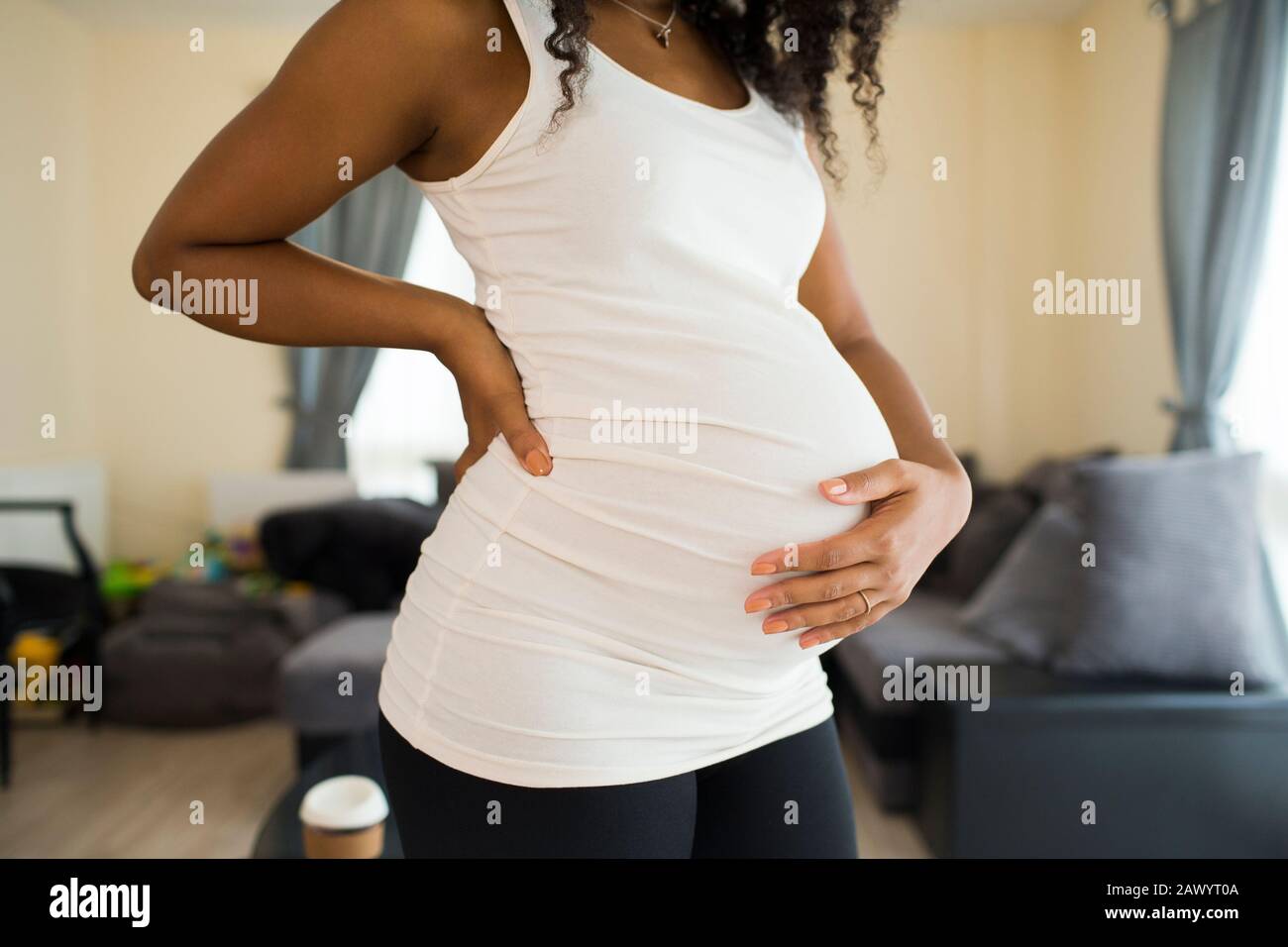 Junge schwangere Frau, die Magen hält Stockfoto