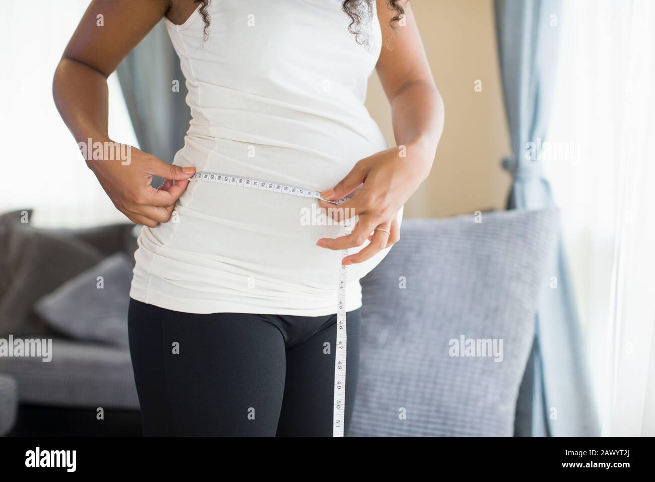 Schwangere Frau Magen mit Maßband messen Stockfoto