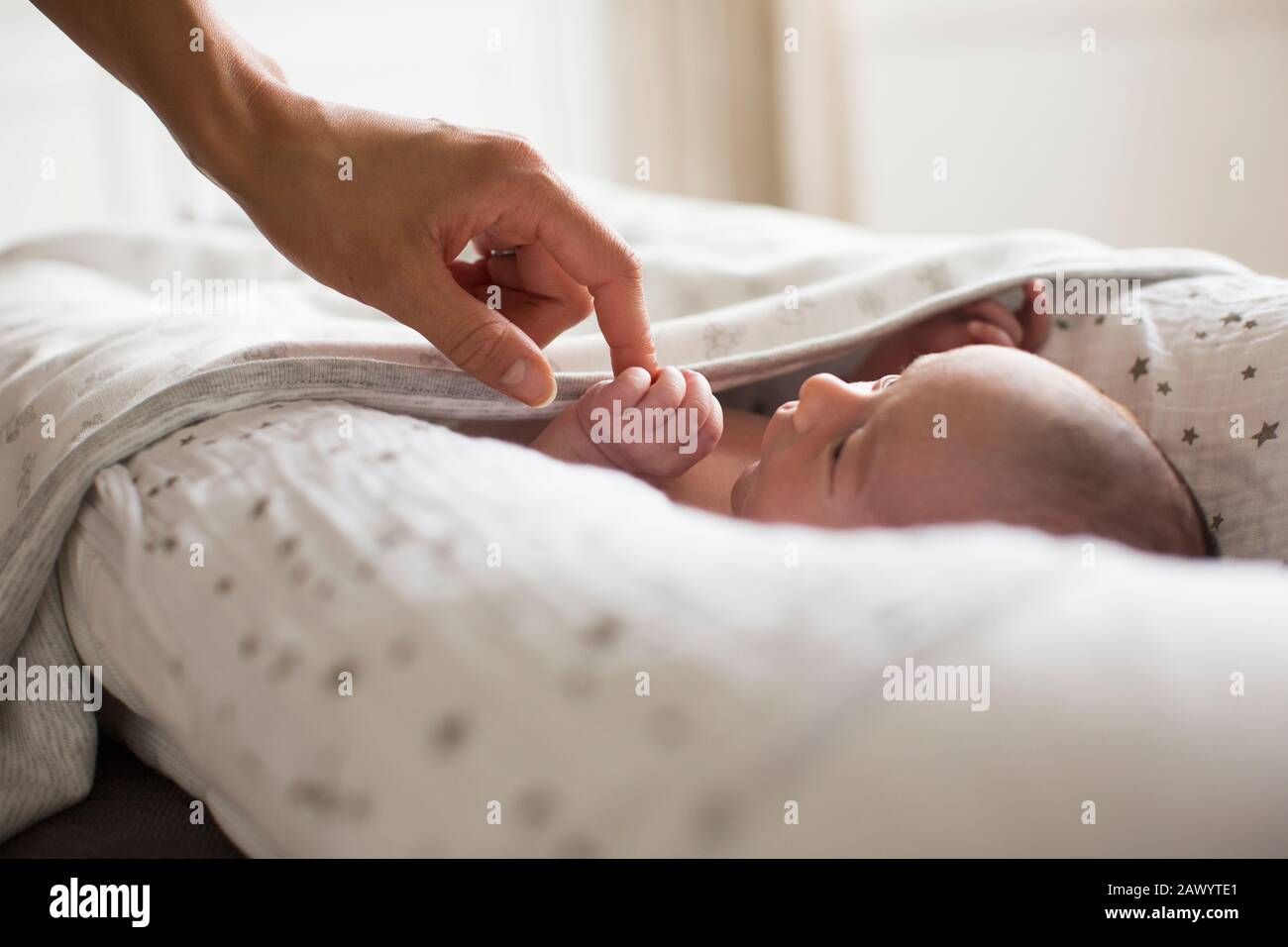 Mutter hält Hände mit neugeborenem Babysohn in der Fagotte Stockfoto