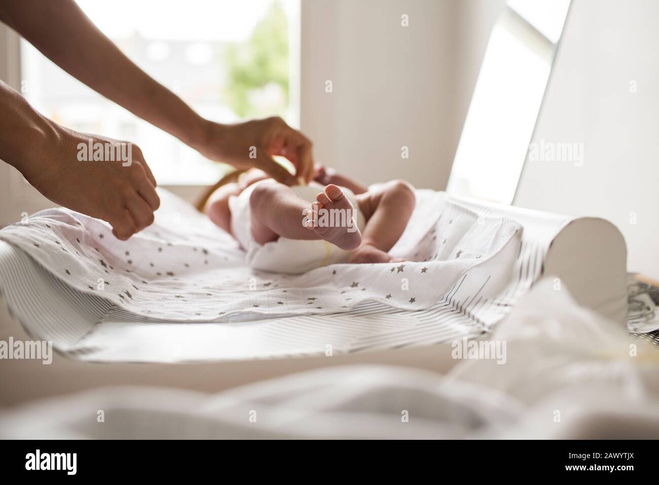 Mutter ändert die Windel des Neugeborenen auf dem Wechseltisch Stockfoto