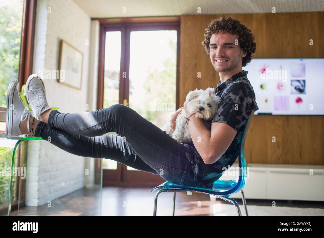 Portrait fröhlicher junger Mann mit Hund im Heimbüro Stockfoto