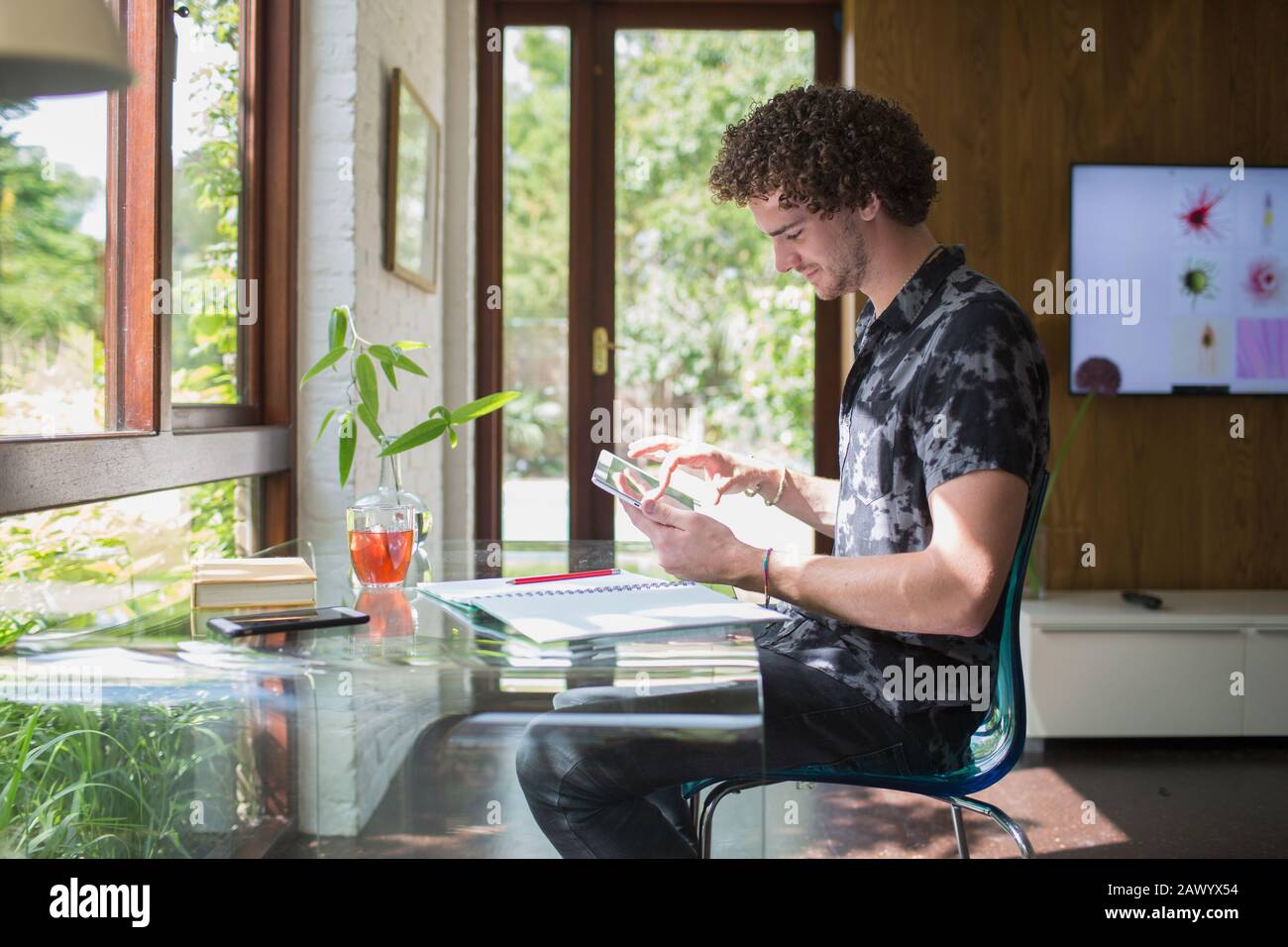 Junger Mann mit digitalem Tablet, der im Heimbüro arbeitet Stockfoto