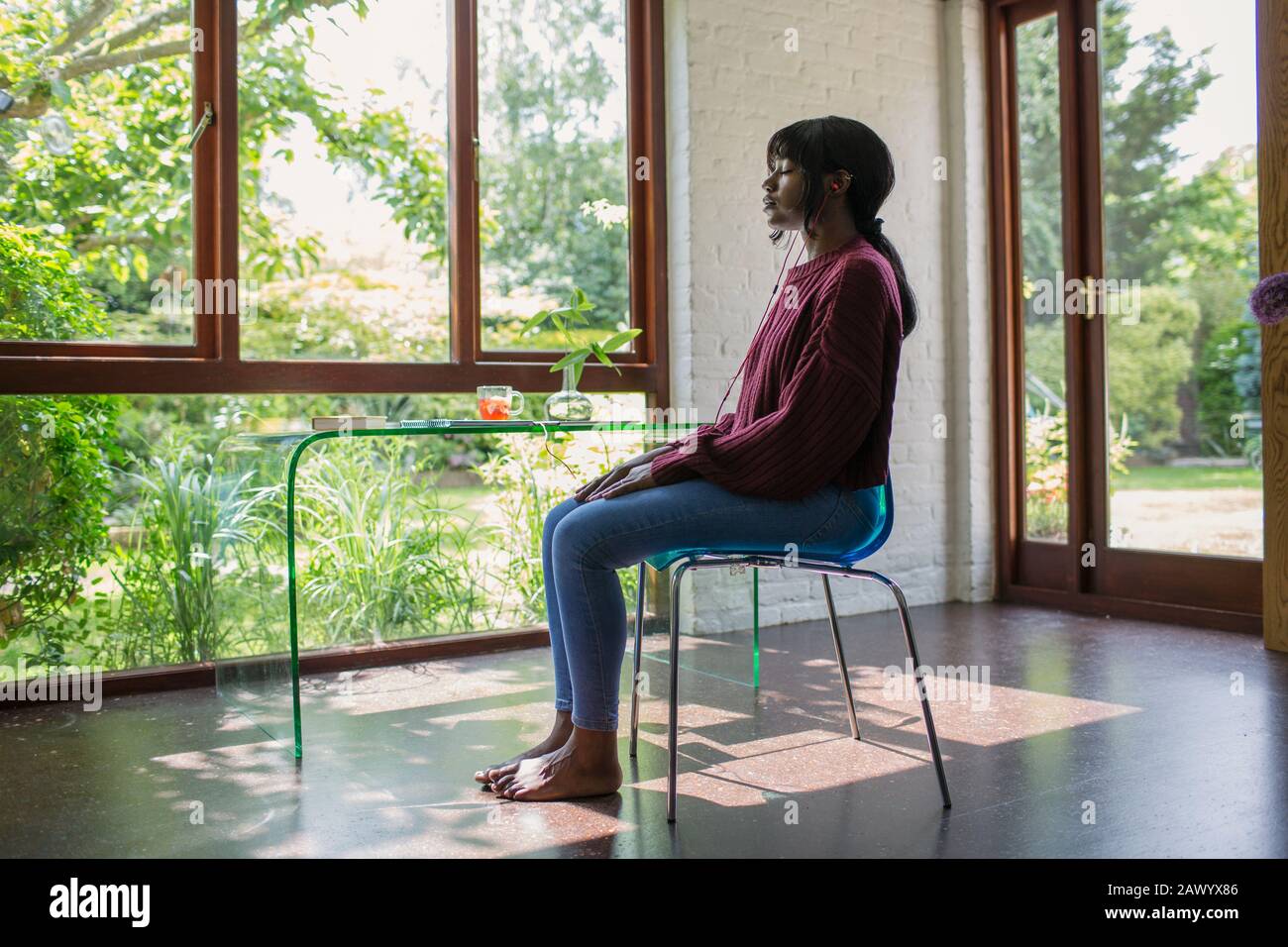 Heitere junge Frau meditiert im ruhigen Heimbüro Stockfoto