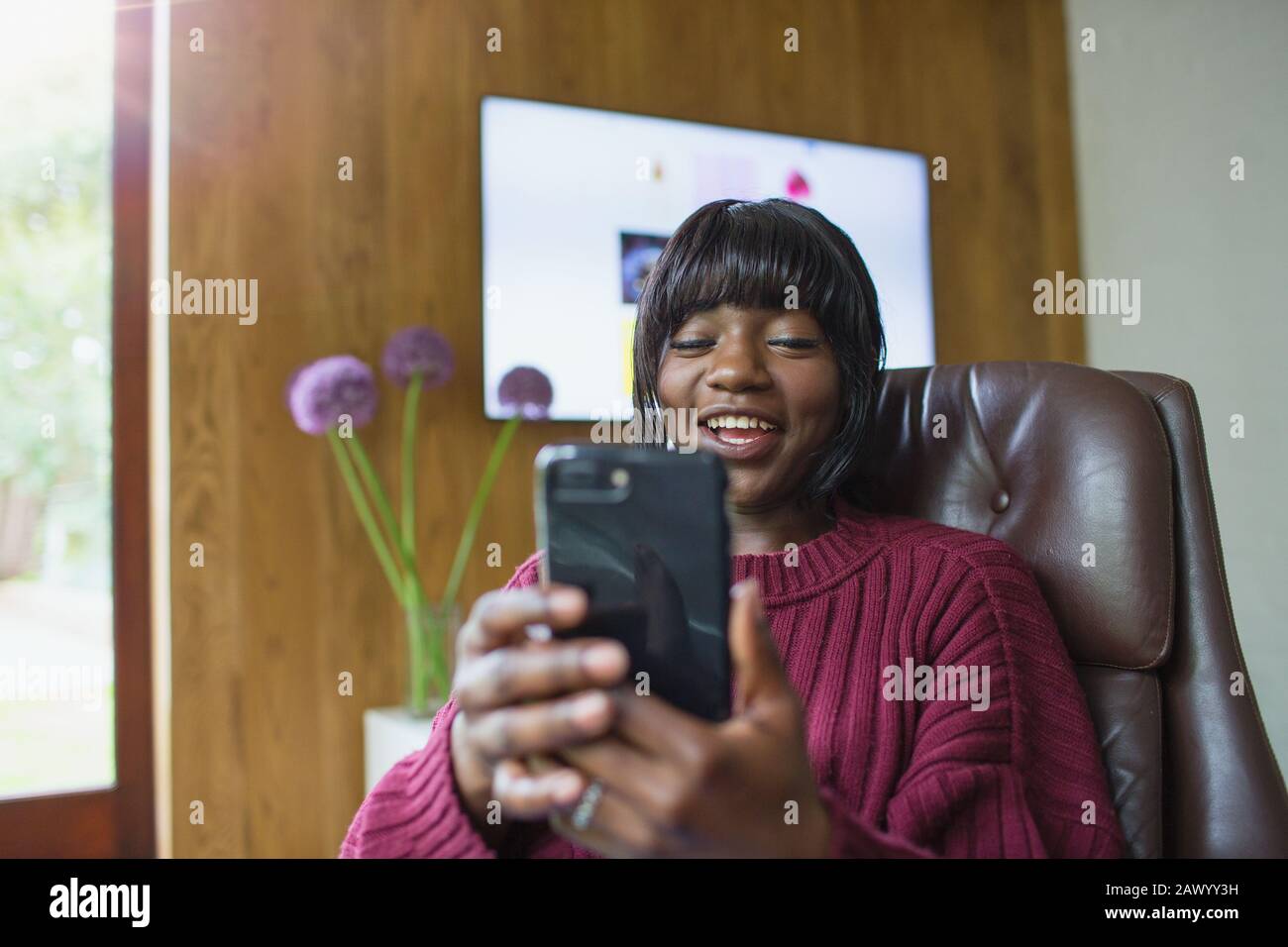 Lächelnde junge Frau mit smart phone Stockfoto