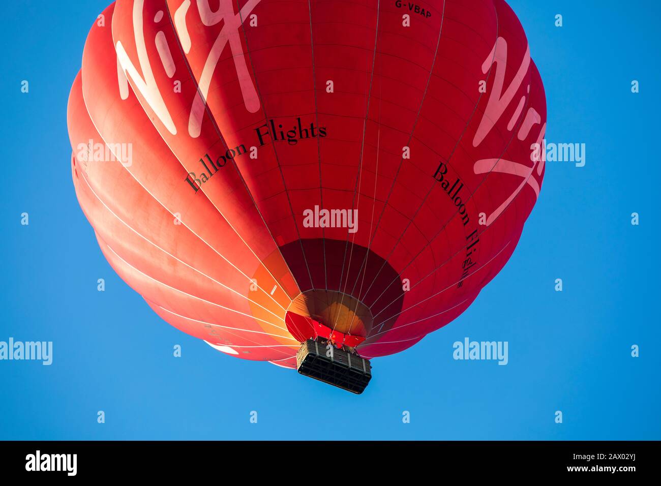 Die Passagiere schauen direkt von unten aus dem Korb eines "Virgin"-Heißluftballons. Stockfoto