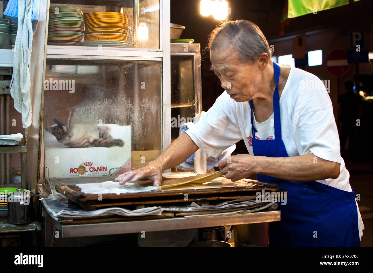 Hong Kong Mann, der traditionelle gedämpfte Reisbrötchen (cheung fen) in einem Congee Shop im Tai Hang Bereich der Hong Kong Insel Stockfoto