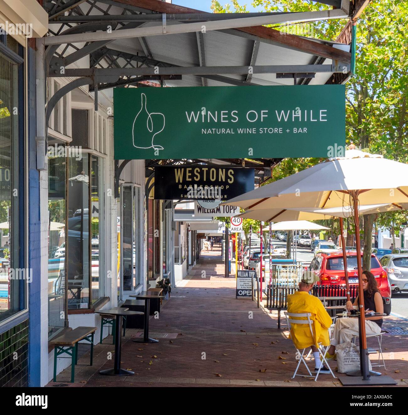 Ein Paar genießen einen Wein im Freien an einem Tisch auf dem Fußweg vor Den Weinen der Weinfar William St Northbridge Perth WA Australia. Stockfoto