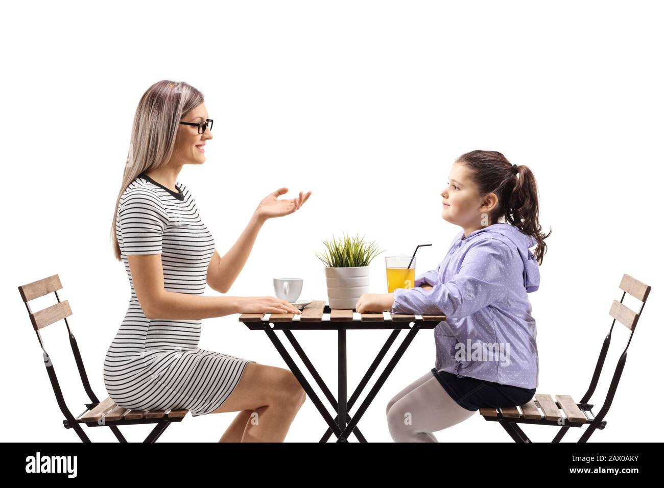 Frau, die mit einem kleinen Mädchen in einem Café spricht, das auf weißem Hintergrund isoliert ist Stockfoto