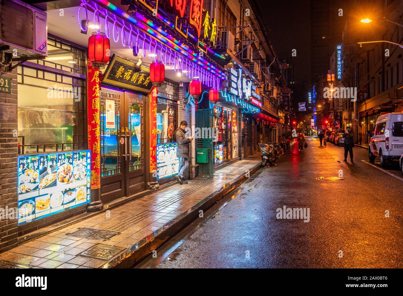 Hell erleuchtete Geschäfte leuchten in der Innenstadt von Shanghai, China, auf unheimlich leeren Straßen. Stockfoto