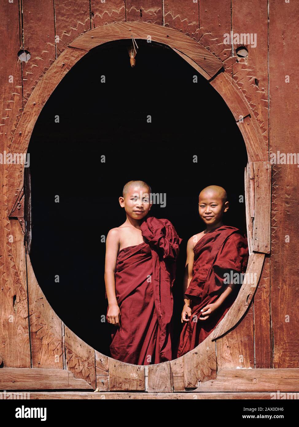 Buddhistische Novizen stehen am Fenster im Shwe Yan Pyay Kloster im Dorf Nyaung Shwe, in der Nähe des Inle Lake, Myanmar (Birma). Stockfoto