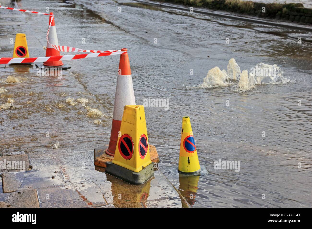 Nach starken Regenfällen sprudelt Wasser aus der Ablaufabdeckung auf Stockfoto