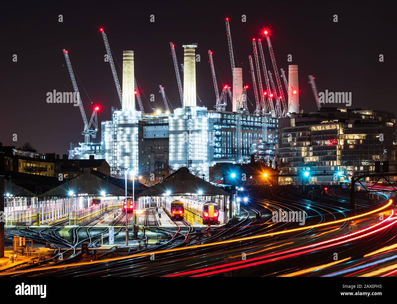 Züge, die nachts am Battersea Power Station vorbeifahren und vom Victoria Station aus fahren Stockfoto