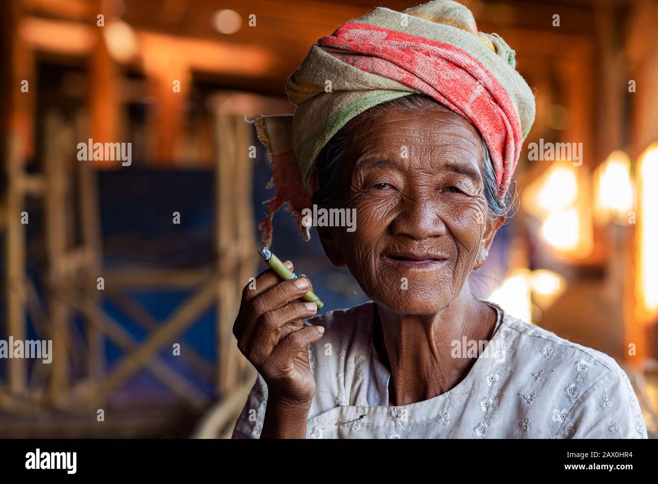 Alte glückliche Dame der Ethnischen Minderheit Der Pa'O, die eine birmanische Zigarre raucht und im Dorf Indein in der Nähe von Inle Lake, Shan State, Myanmar (Birma) lächelt. Stockfoto