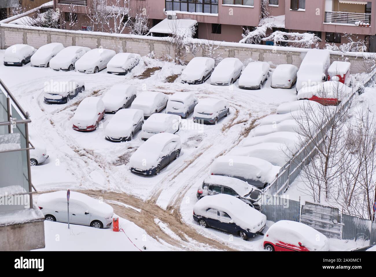 Reihen von geparkten, schneebedeckten Autos in einem Wohngebiet von Bukarest, Rumänien, tagsüber - Blick in den hohen Winkel. Stockfoto