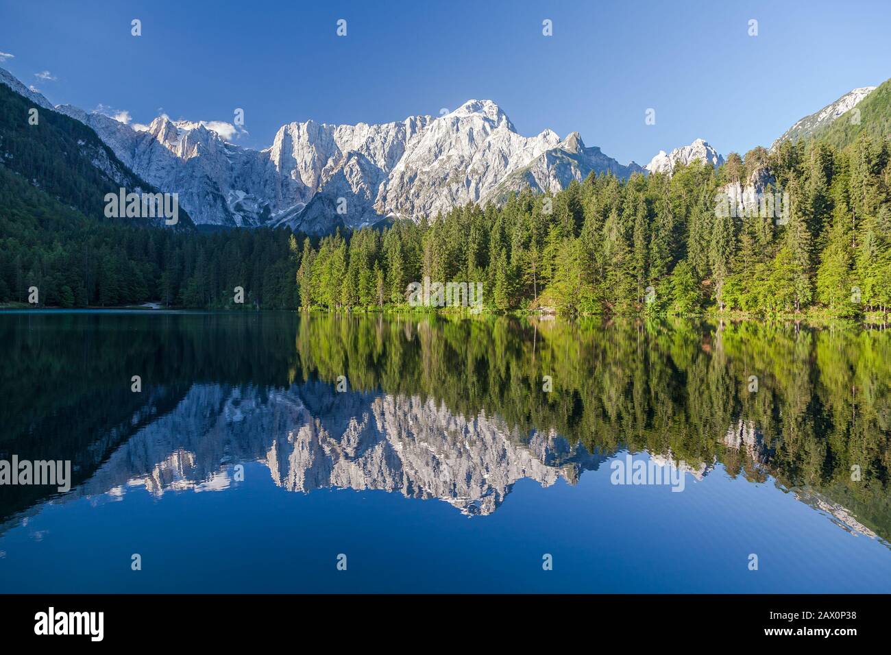 Malerischer Panoramablick auf den idyllischen Alpensee mit kristallklaren Reflexionen bei schönem Morgenlicht bei Sonnenaufgang an einem sonnigen Tag im Frühjahr Stockfoto