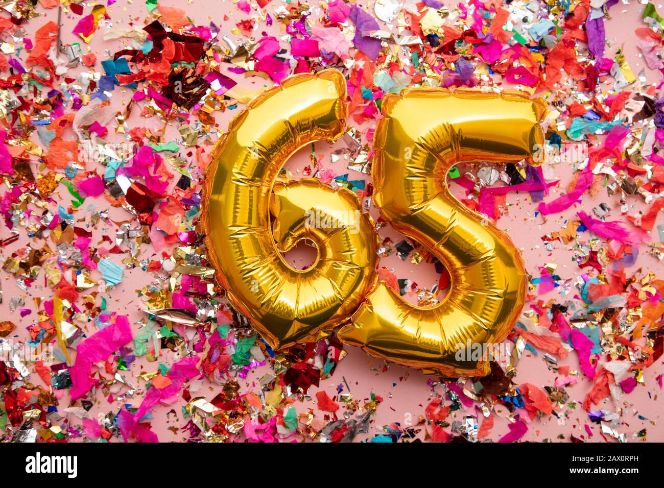 Nummer 65 Goldgeburtstag Ballon auf einem Konfetti-Glitzer-Hintergrund Stockfoto