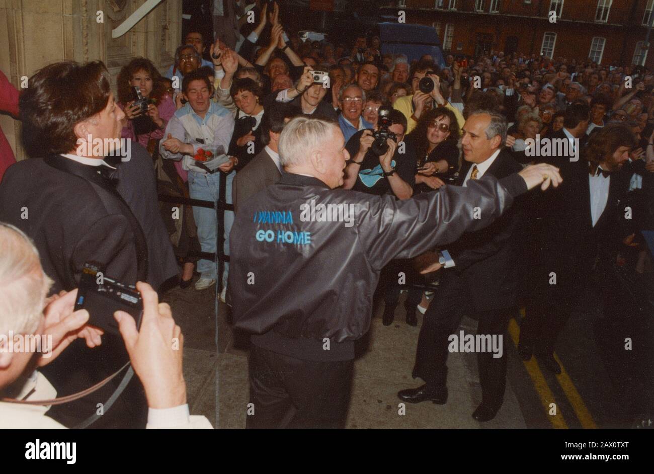 Frank Sinatra, Royal Albert Hall, London, 1989. Sinatra, der in die Royal Albert Hall kommt, schüttelt mit Fans die Hände und trägt eine Jacke mit den Worten "I Wanna Go Home". Im April 1989 kamen drei der größten Ikonen der amerikanischen Popmusik, Frank Sinatra, Liza Minnelli und Sammy Davis Jr, in Frank, Liza und Sammy zusammen: Das ultimative Ereignis. Stockfoto