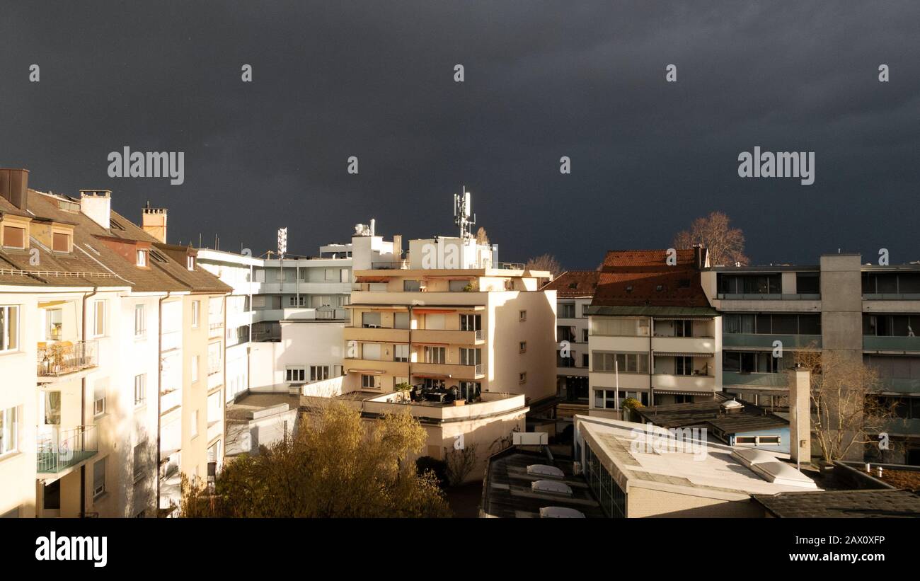 Sonnenschein und dunkle Wolken über der Stadt Stockfoto