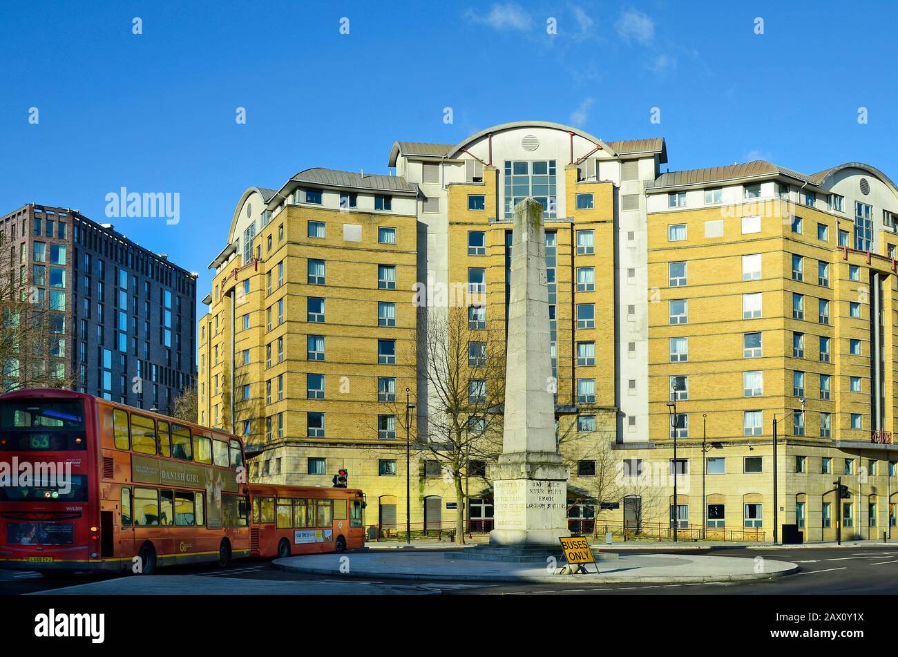 London, Großbritannien - 15. Januar 2016: Gebäude und Obelisk mit traditionellen roten Doppeldeckerbussen an einem Kreisverkehr in Southwark Stockfoto