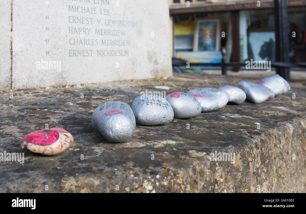 Gedenksteine eines mit Mohn und Botschaften bemalten Kriegsdenkmals, die vermutlich von Pfadfindern in einem Kriegsdenkmal in Arundel, West Sussex, Großbritannien, aufgestellt wurden. Stockfoto