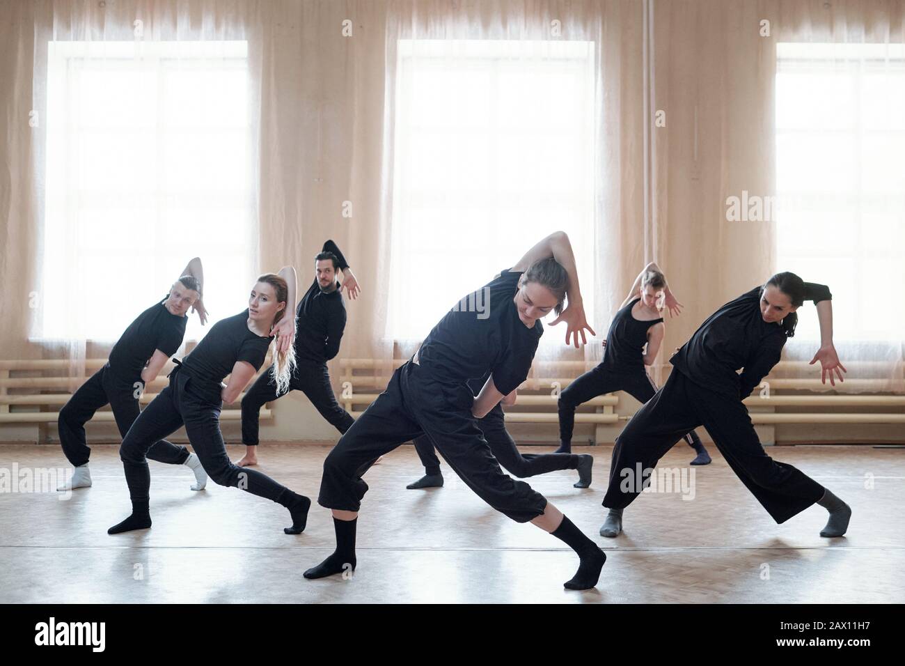 Team zeitgenössischer Tänzer, die an neuen Tanzbewegungen in ihrem Probststudio arbeiten, horizontal Shot Stockfoto
