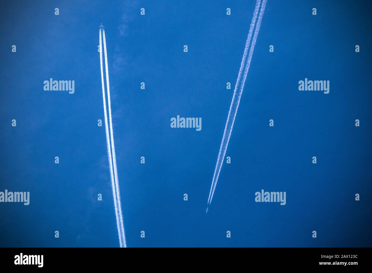 Zwei Flugzeuge, die in Reiseflughöhe in einem blauen Himmel vom Boden aus über London, England, vorbeifliegen Stockfoto