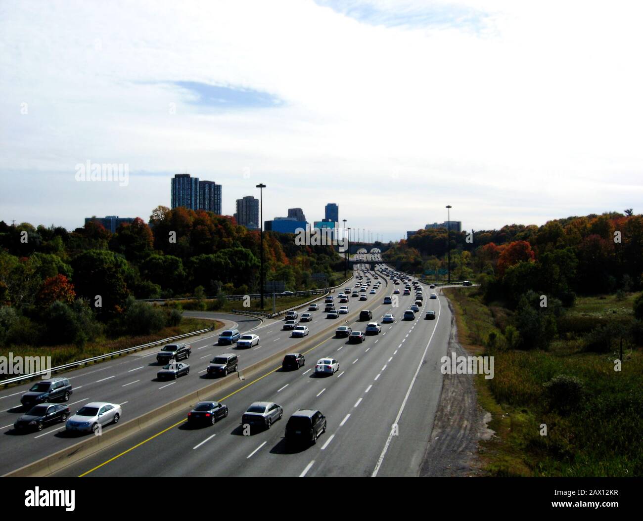 Viel befahrene Hauptverkehrszeit. 6-spuriger Don Valley Parkway Highway in Toronto. Abnehmende Perspektive. Mehrebenenwohnanlagen jenseits. Stockfoto