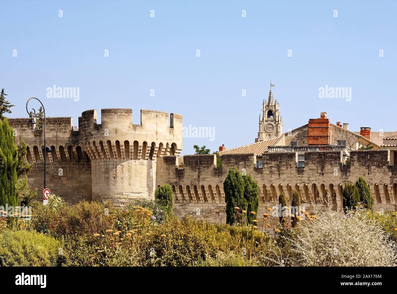 Alte Stadtmauer, Stein, crenelliert, Vegetation, verzierter Uhrturm, Provence, Avignon; Frankreich; Sommer; horizontal Stockfoto