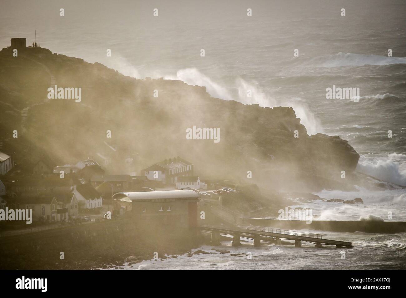 Wellen und Seespray waschen sich über Felsen in Sennen Cove, in der Nähe von Land's End, Cornwall, wo immer noch eine gelbe Windwarnung in Kraft ist, während der Sturm Ciara über einige Teile des Vereinigten Königreichs zurückbleibt. Stockfoto