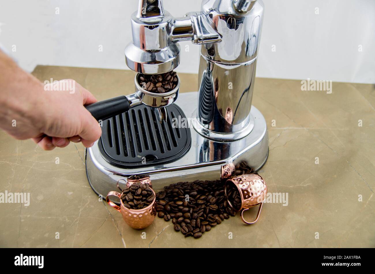 Frisch gerösteter Kaffee in Espresso-Arbeit. Bei der Zubereitung von  Kaffee. Espresso-Kaffeemaschine im Retro-Stil. Kaffeebohnen und  Metallbecher. Kaffee ist ein guter Sta Stockfotografie - Alamy