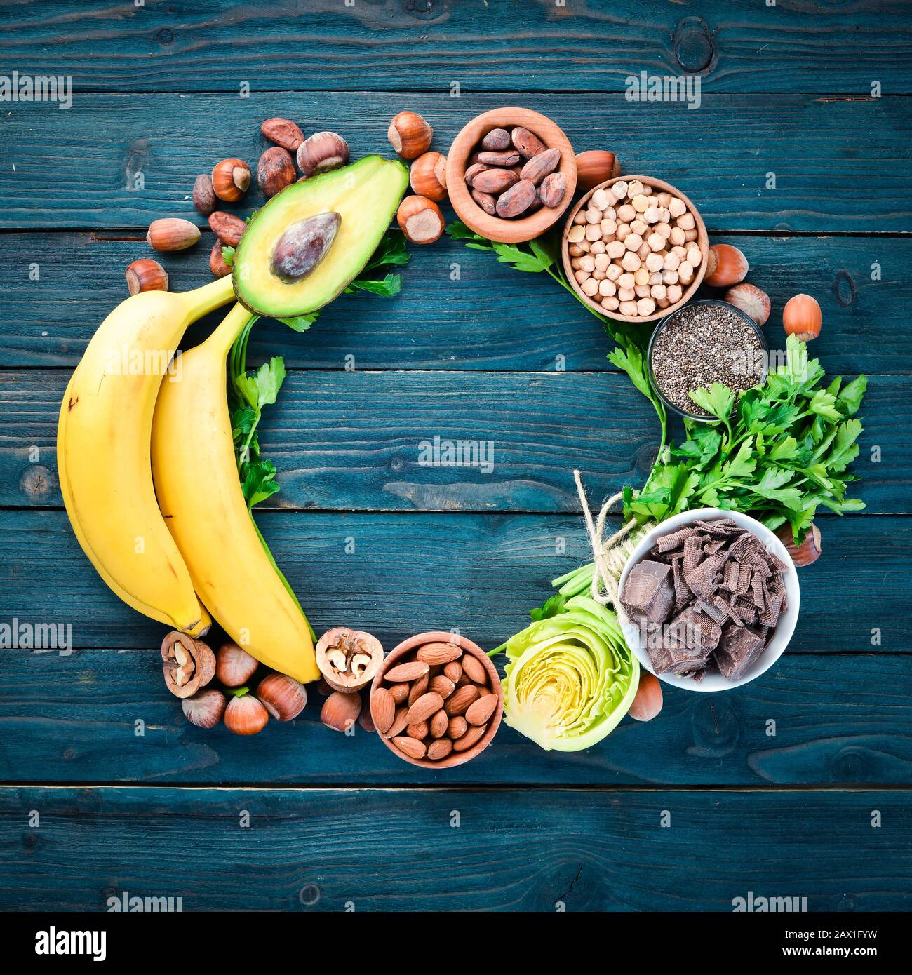 Lebensmittel, die natürliches Magnesium enthalten. Mg: Schokolade, Banane,  Kakao, Nüsse, Avocados, Brokkoli, Mandeln. Draufsicht. Auf blauem  Holzhintergrund Stockfotografie - Alamy