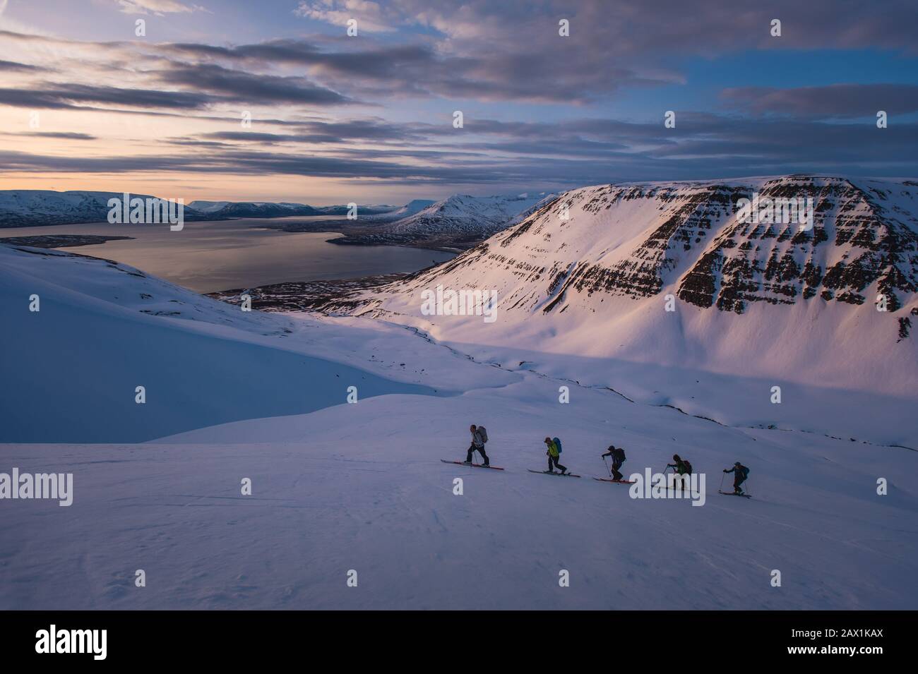 Gruppe von Menschen im Backcountry Skifahren bei Sonnenaufgang in Island Stockfoto