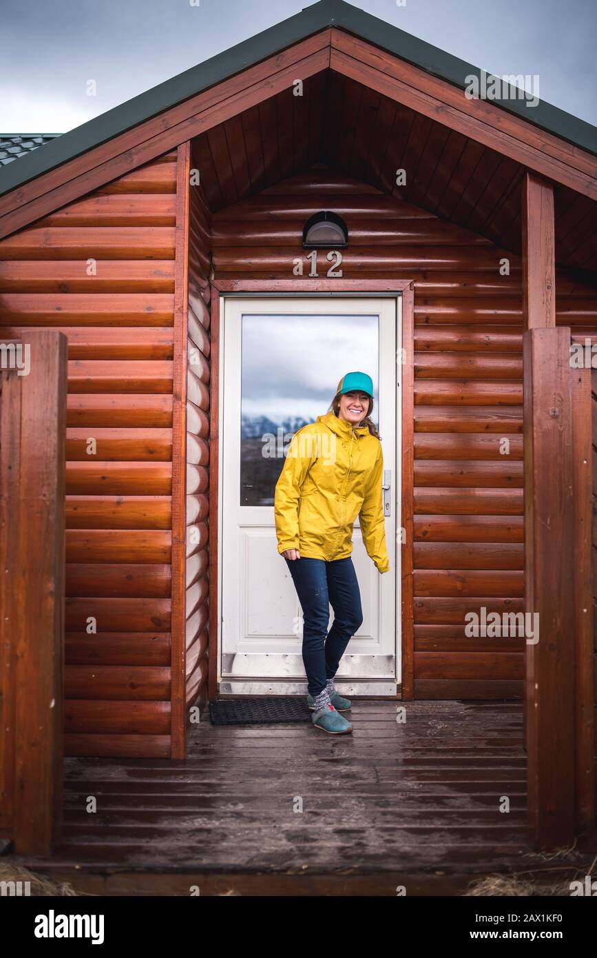 Frau in gelber Jacke vor der Haustüre in Island Stockfoto