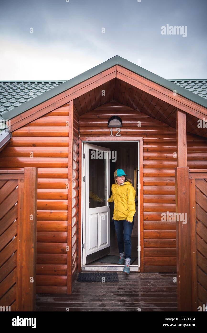 Frau in Gelb, die durch die Haustür eines Hauses in Island geht Stockfoto