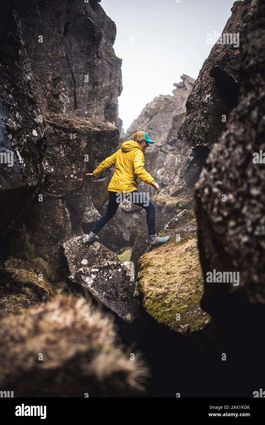Frau in gelber Jacke, die thermische Risse in Island erkundet Stockfoto