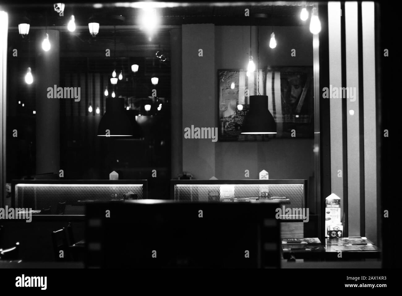 In einer Bar, Tische mit Sitzplätzen und zwei Lampen, schwarz und weiß Stockfoto
