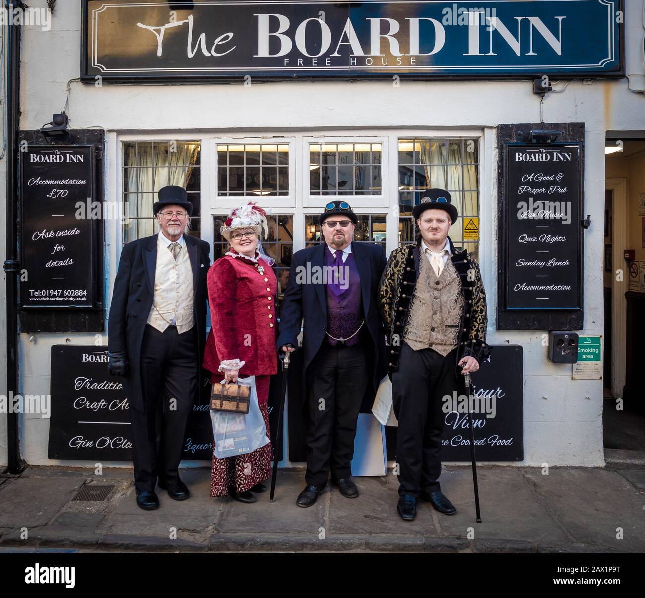 Vier Personen kleideten sich während des Steampunk-Wochenendes, Whitby, Großbritannien, vor dem Board Inn an. Stockfoto