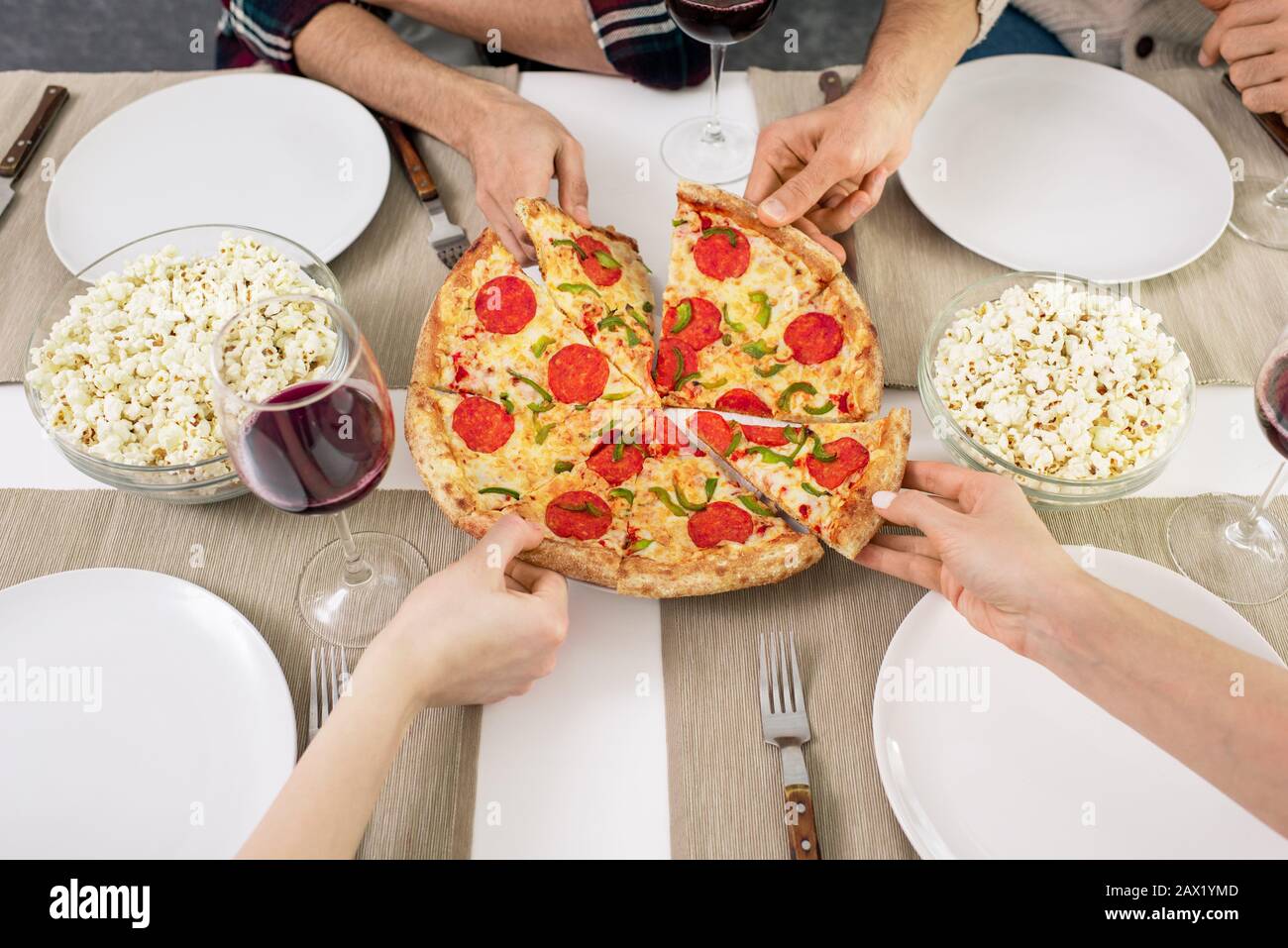 Horizontaler, hochwinkeliger Blick, der von nicht erkennbaren Personen mit leckeren Pizza-Scheiben aufgenommen wird Stockfoto