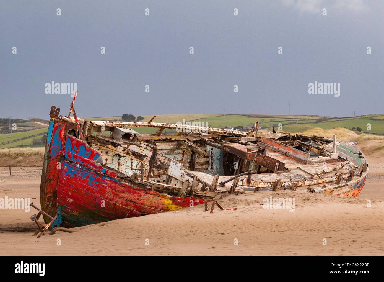 Ein buntes Schiffswrack ruht am Strand von Crow Point in Nord-Devon, England. Stockfoto