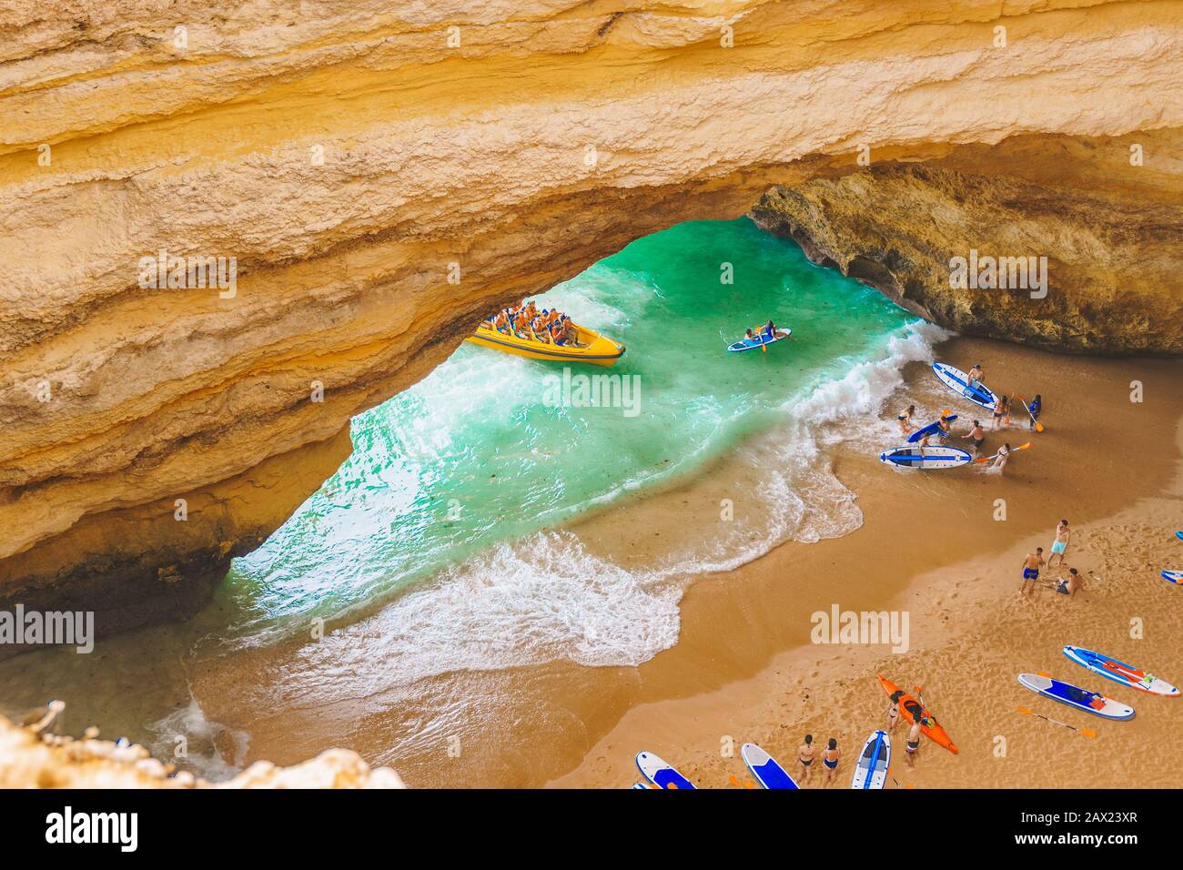 Benagil Höhle in Portugal, Carvoeiro Algarve, Lagos. Touristen, die auf Paddle-Boards für SUP, Kajak, Motorboote nach Praia de Benagil schwimmen. Benagil Cave t Stockfoto