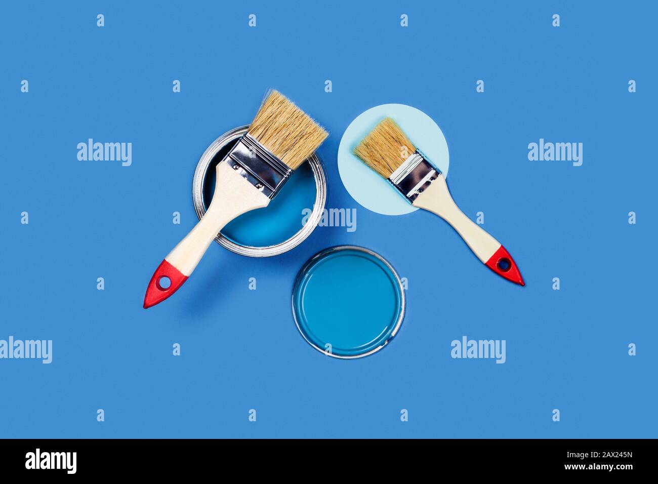 Foto für Präsentationsapartment Reparaturen. Blauer Hintergrund mit einer Holz-Quaste und einer Kreis- und LackierDose. Flaches Layout, Draufsicht, Kopierbereich. Stockfoto