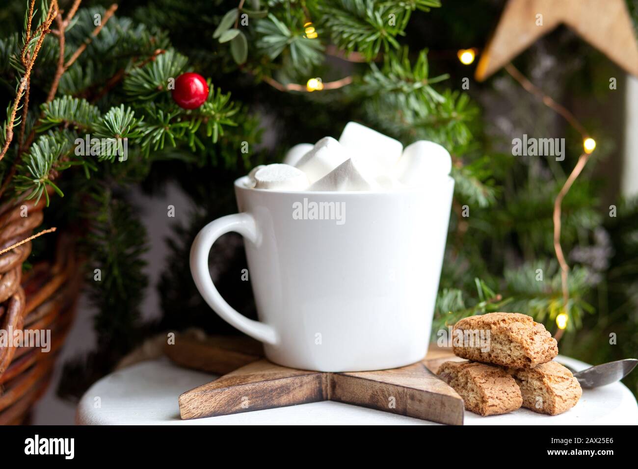 Kaffee in einer weißen Tasse mit Marshmallows. Festlicher Kaffee am Morgen mit traditionellen italienischen Cantuccini-Plätzchen. Kaffeetasse auf grünem Tannenhintergrund B. Stockfoto