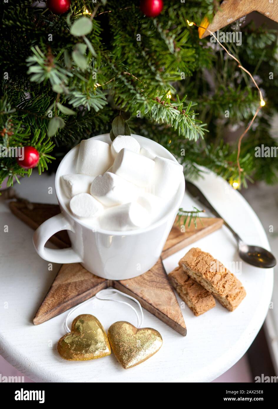 Kaffee in einer weißen Tasse mit Marshmallows. Festlicher Kaffee am Morgen mit traditionellen italienischen Cantuccini-Plätzchen. Kaffeetasse auf grünem Tannenhintergrund B. Stockfoto