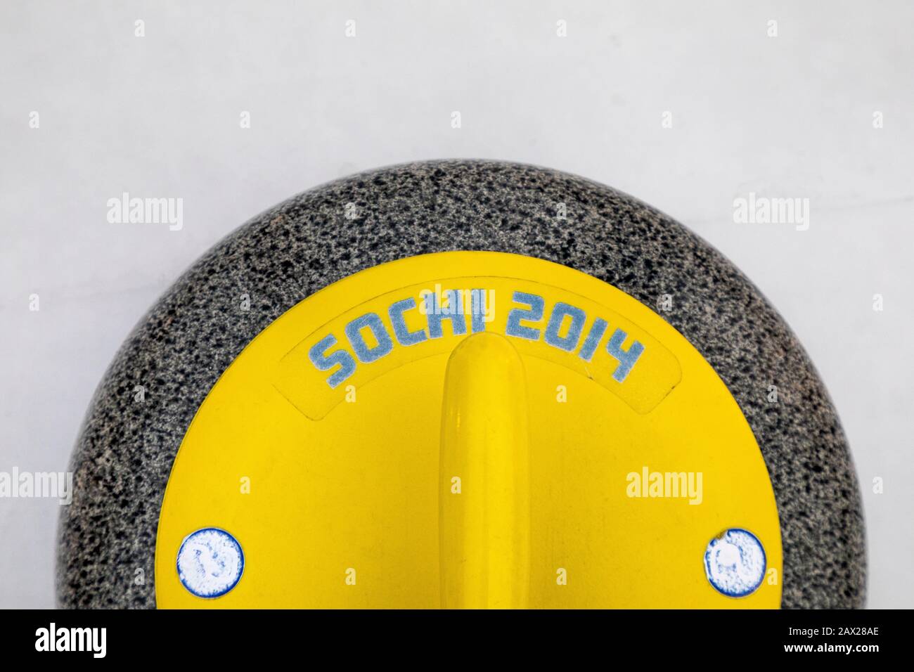 Draufsicht auf einen gelben Stein aus Granit zum Curling mit der Aufschrift 'Sochi 2014' Stockfoto