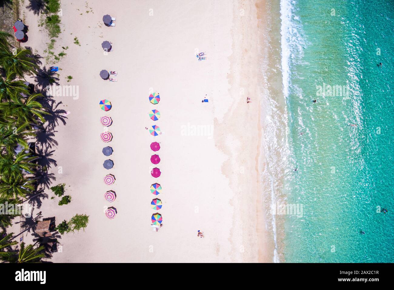Blick auf den Strand mit farbenfrohen Sonnenschirmen und Badegästen am Strand von Nacpan in El Nido, Palawan, Philippinen. Stockfoto