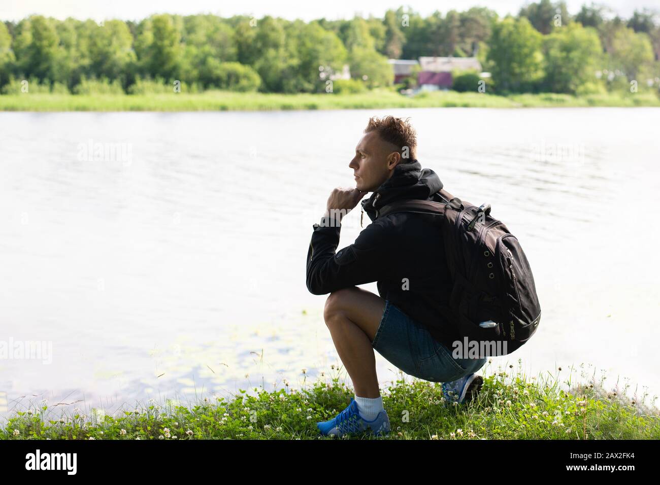 Der Mann sieht gedacht aus, am Ufer des Sees. Stockfoto