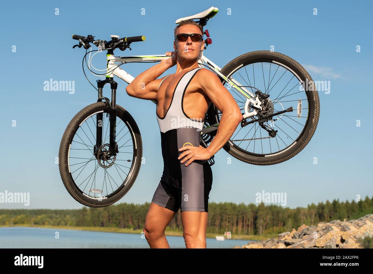 Ein Mann mit einem Fahrrad am Seeufer. Stockfoto