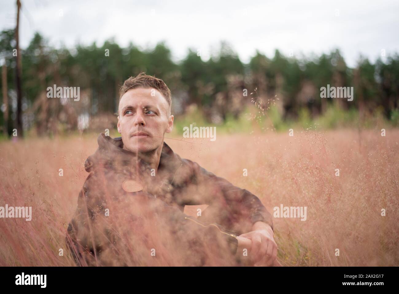 Der Mann sitzt auf einem dicken Feld und denkt. Stockfoto