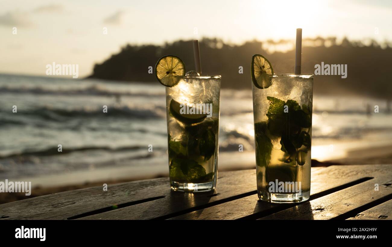 Frische Mojito-Getränke, zwei Gläser gegen den Sonnenuntergang am warmen Abend am Strand Stockfoto