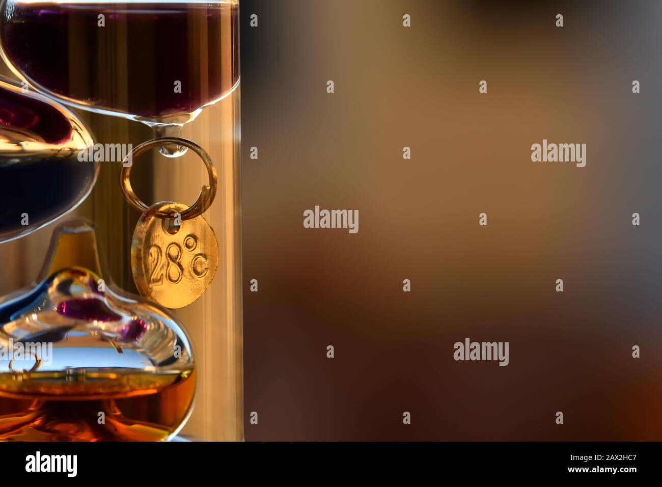 Galileo-Thermometer mit hellen Farben und Reflexionen in verschiedenen Hintergründen Stockfoto